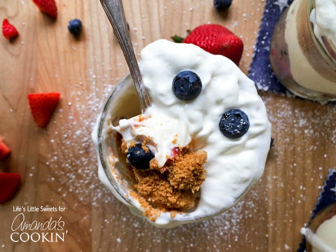 An overhead photo of a spoonful of no bake berry cheesecake trifle in a mason jar.