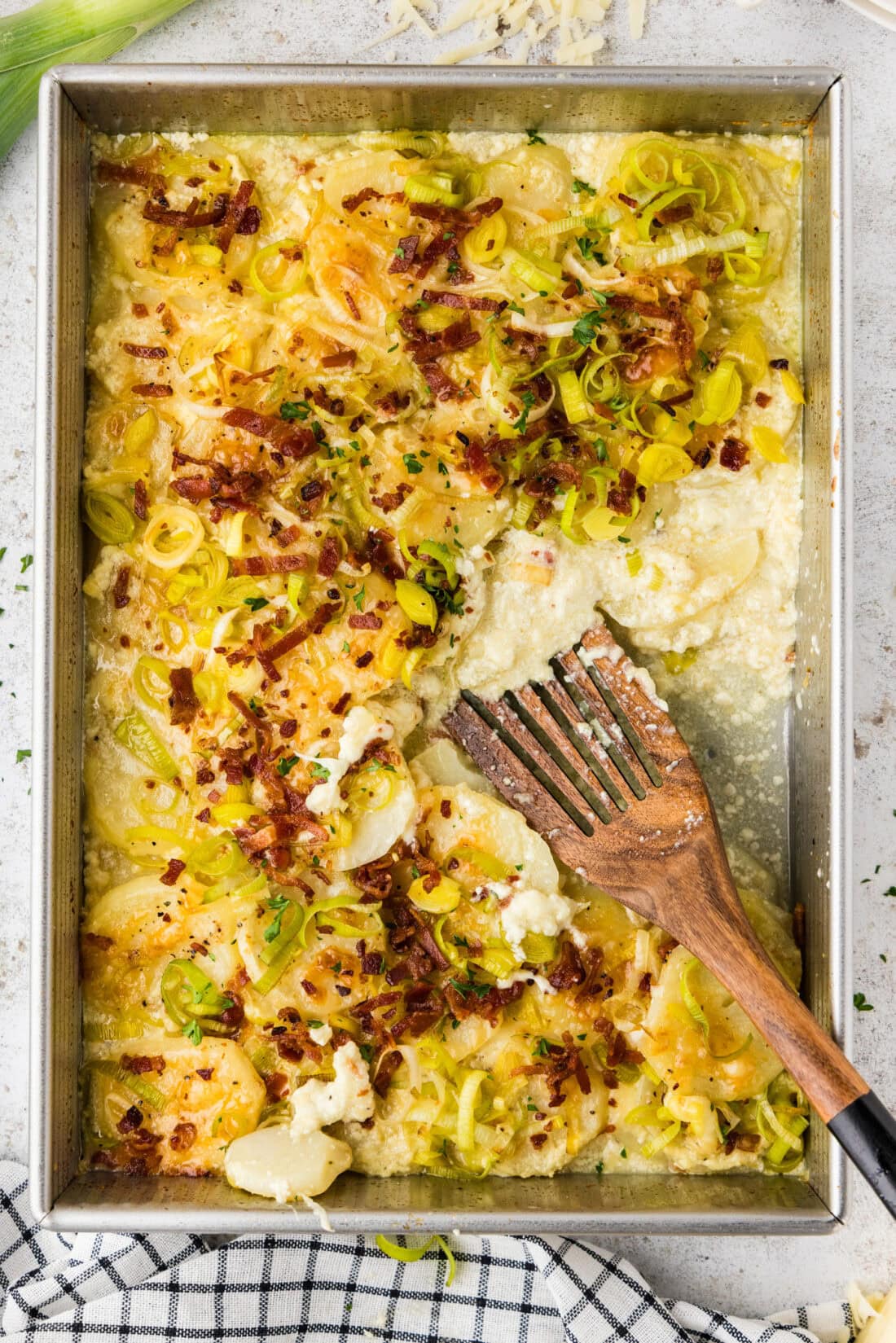 Spatula in a pan of Potatoes Au Gratin with Bacon and Leeks
