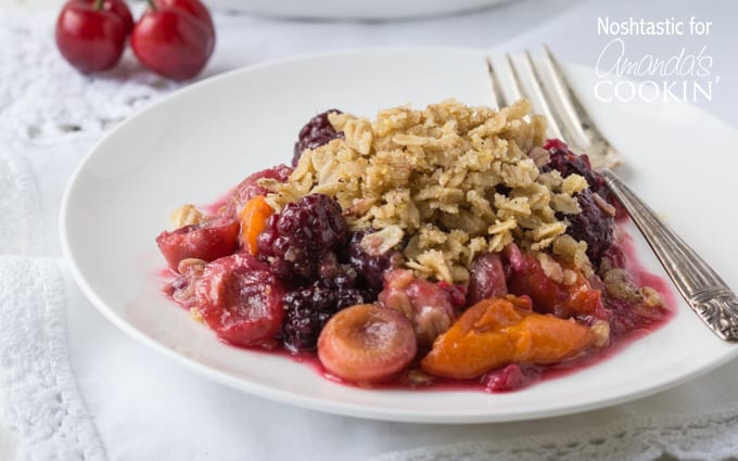 A close up of summer fruit crisp on a white plate.