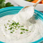 spooning out some Homemade Buttermilk Ranch Dressing from a bowl