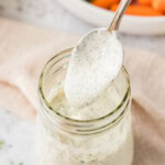 lifting a spoonful of Homemade Buttermilk Ranch Dressing from jar