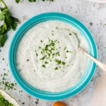 overhead of blue bowl full of Homemade Buttermilk Ranch Dressing with a spoon in it