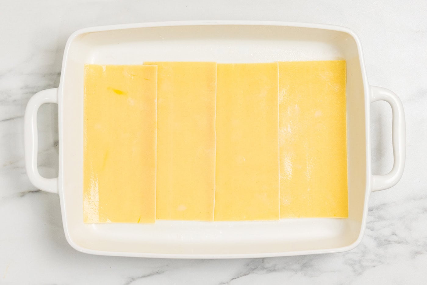 layered lasagna noodles in baking dish
