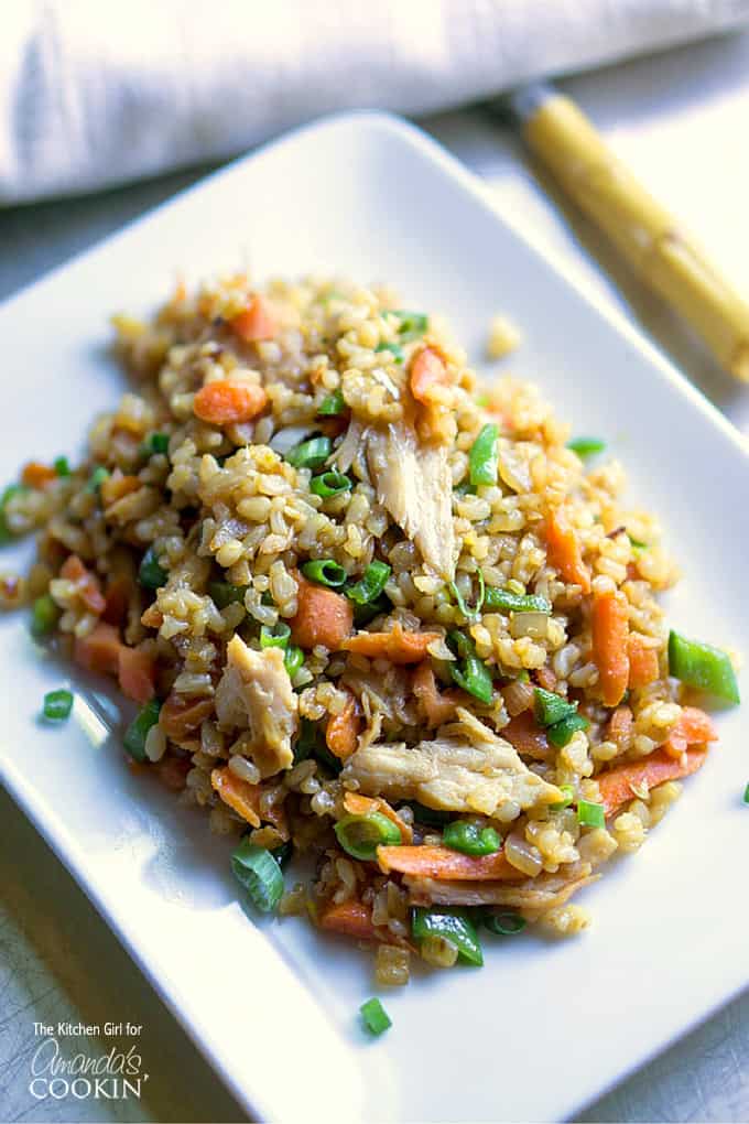 A close up photo of teriyaki chicken and rice on a white plate.