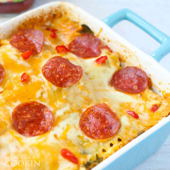 A close up photo of pizza lasagna in a blue casserole dish.