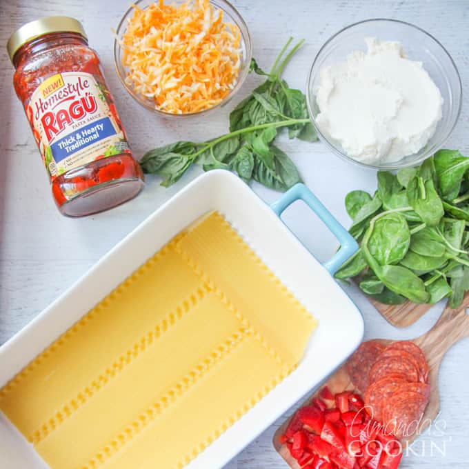An overhead photo of the ingredients for pizza lasagna spread out on the counter.