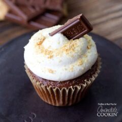 A close up of a s'mores cupcake topped with a Hershey bar piece.