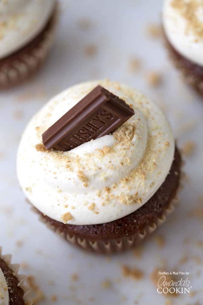 A close up overhead of a s\'mores cupcake topped with a Hershey bar piece. 