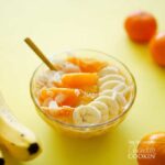 A photo of an almond orange smoothie bowl topped with fresh orange and bananas.