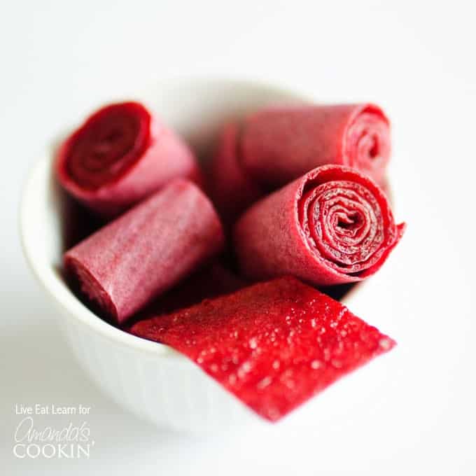 A close up of plum fruit roll ups in a white bowl.