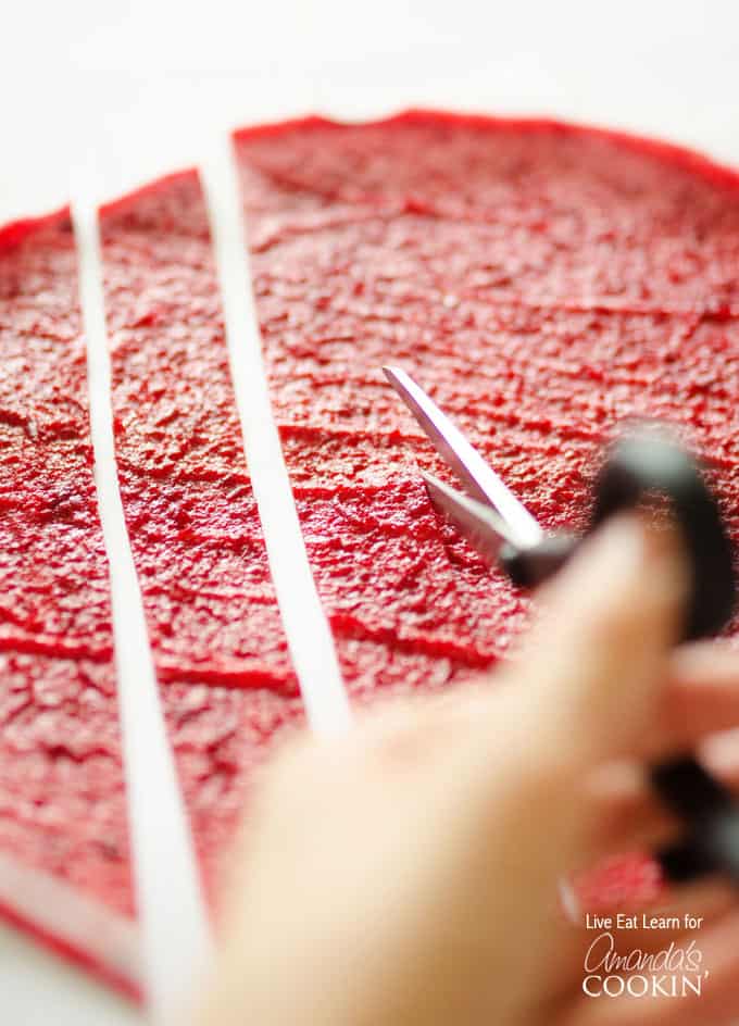 A close up of homemade fruit roll ups bring cut into strips.