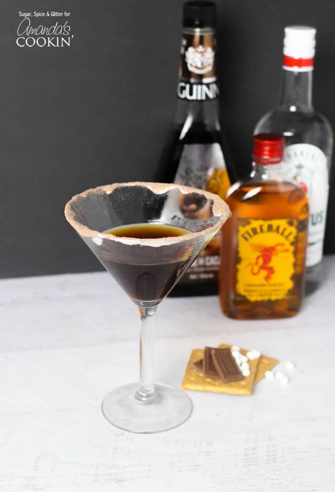 A photo of a s\'mores martini with a fireball bottle in the background.