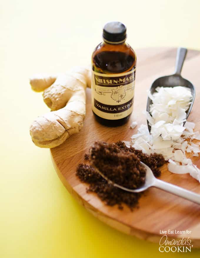 A photo of some of the needed ingredients to make a cozy coconut smoothie: shaved coconut, packed brown sugar, ginger and vanilla extract.