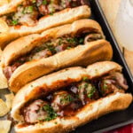 Slow Cooker BBQ Meatball Subs on a tray with chips