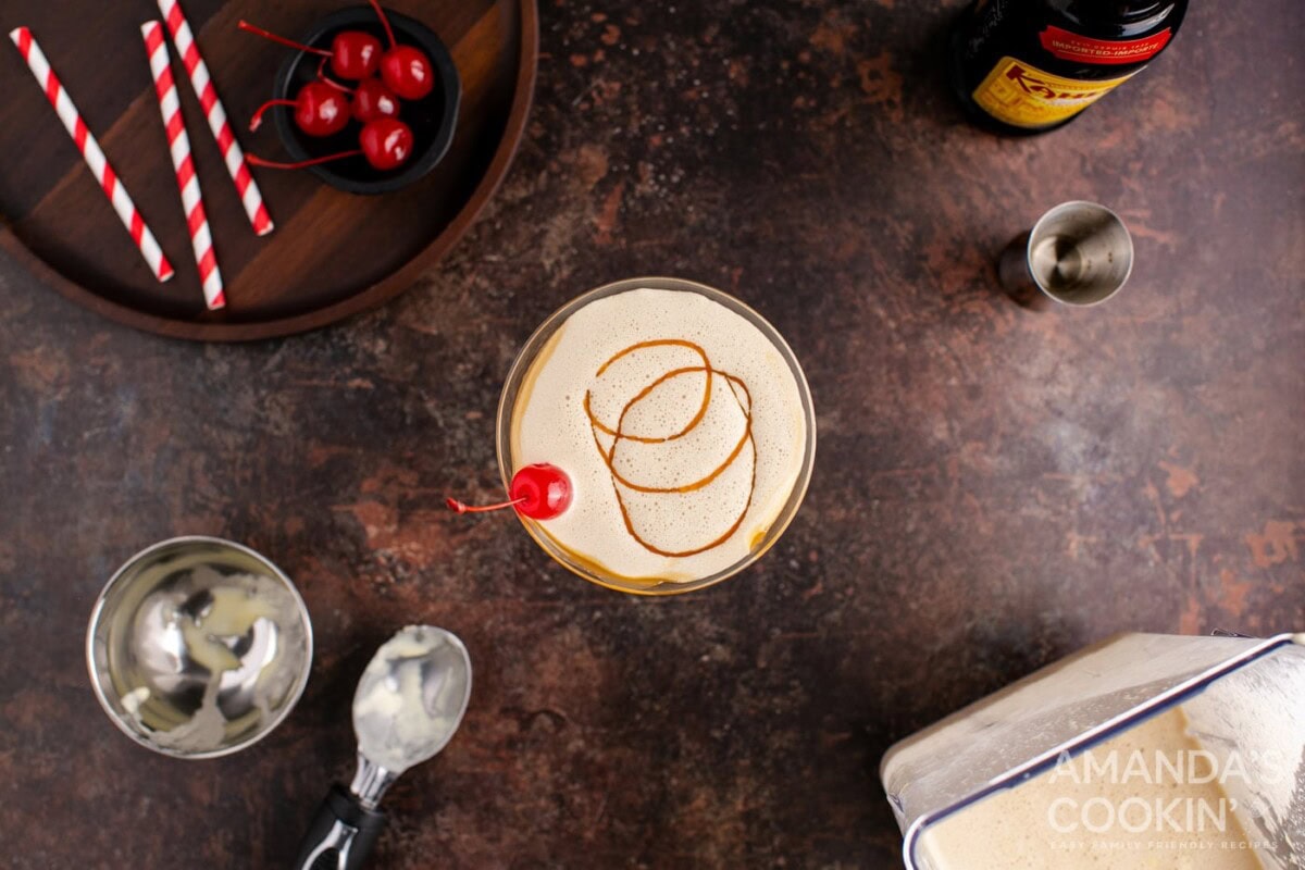 butterscotch milkshake cocktail in a martini glass with a cherry garnish