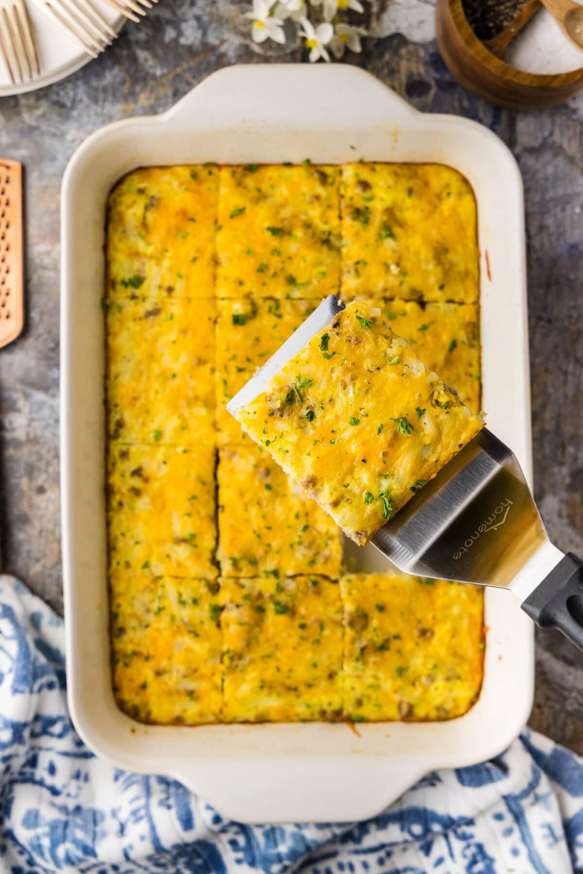 A close up of a white baking dish filled with fresh baked turkey hash brown breakfast casserole