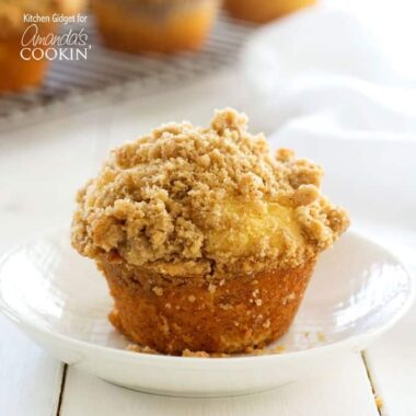 A close up of a cinnamon streusel muffin in a white bowl.