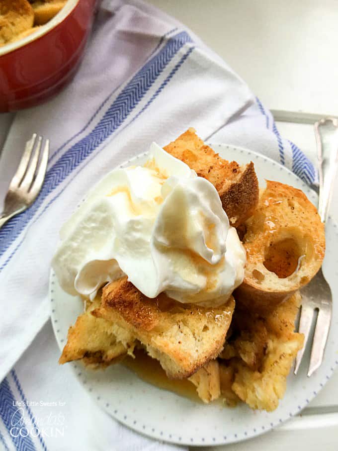 A close up of french toast casserole topped with vanilla whipped cream.