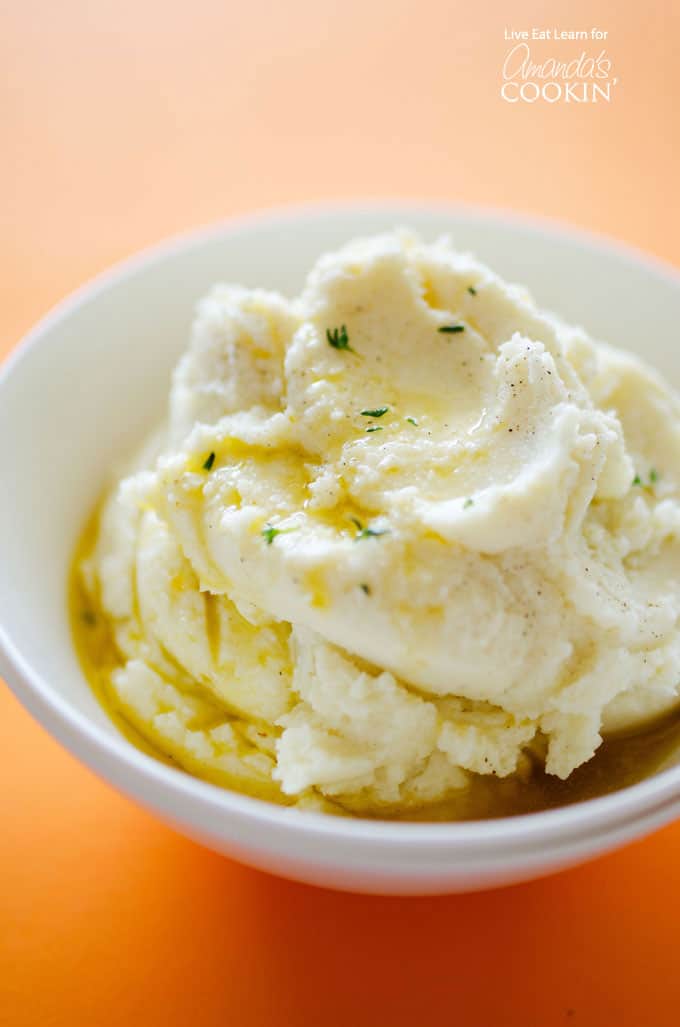 A close up of mashed cauliflower with melted butter on top.