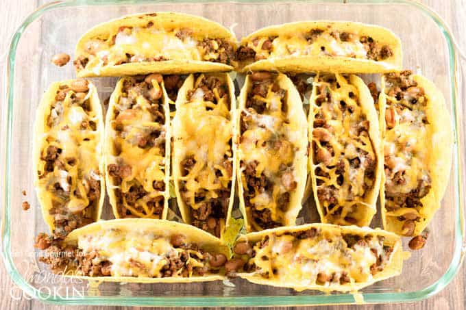 An overhead of beef and bean tacos in  clear dish.