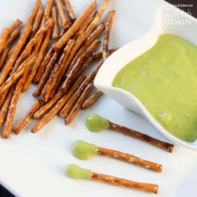 A plate with pretzel sticks, a bowl of boogers (cheese wiz), and boogers on a stick.