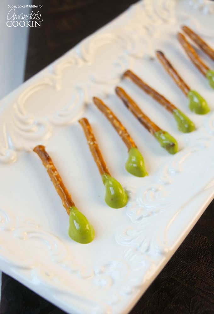 Pretzel sticks with green cheese whiz dipped on one end.