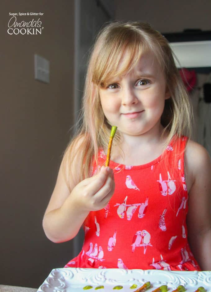 A little girl holding a booger on a stick.