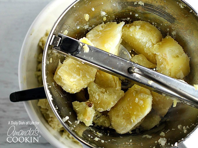 An overhead of whole, skinned potatoes in a food mill.