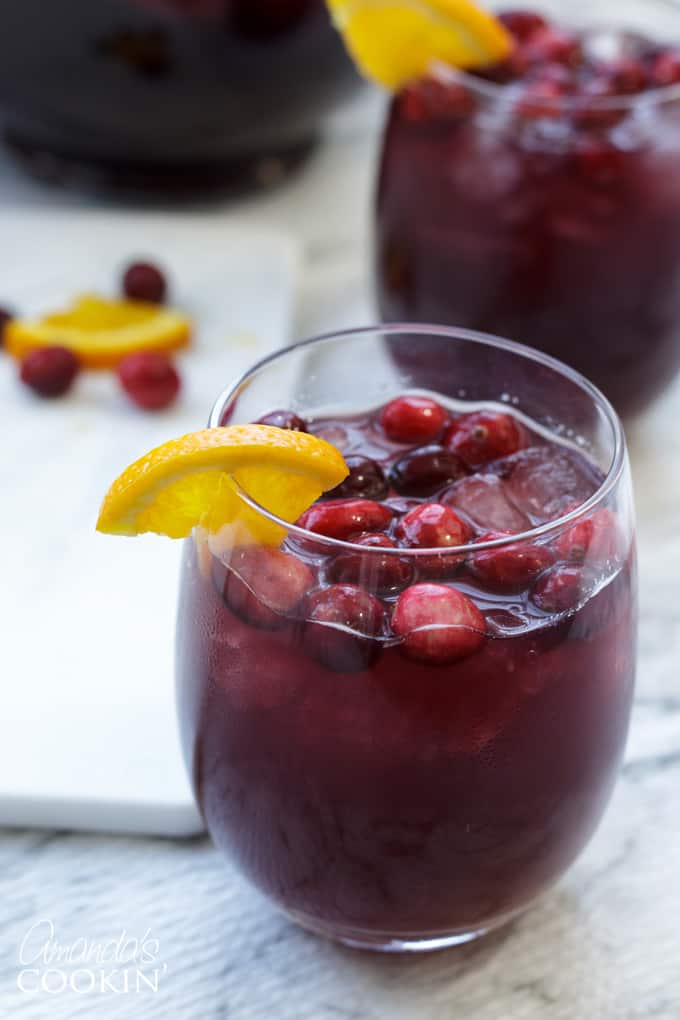 glass of cranberry sangria with orange garnish