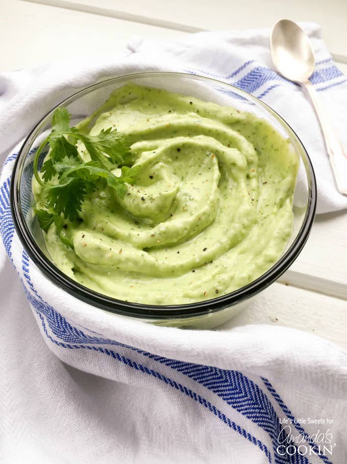 A photo of a bowl of avocado sauce for salmon tacos.