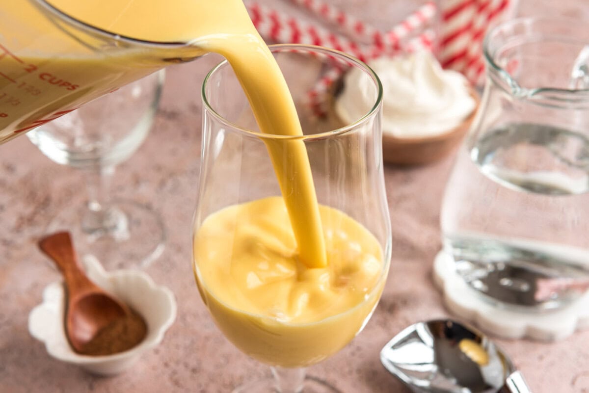 pouring eggnog into glass