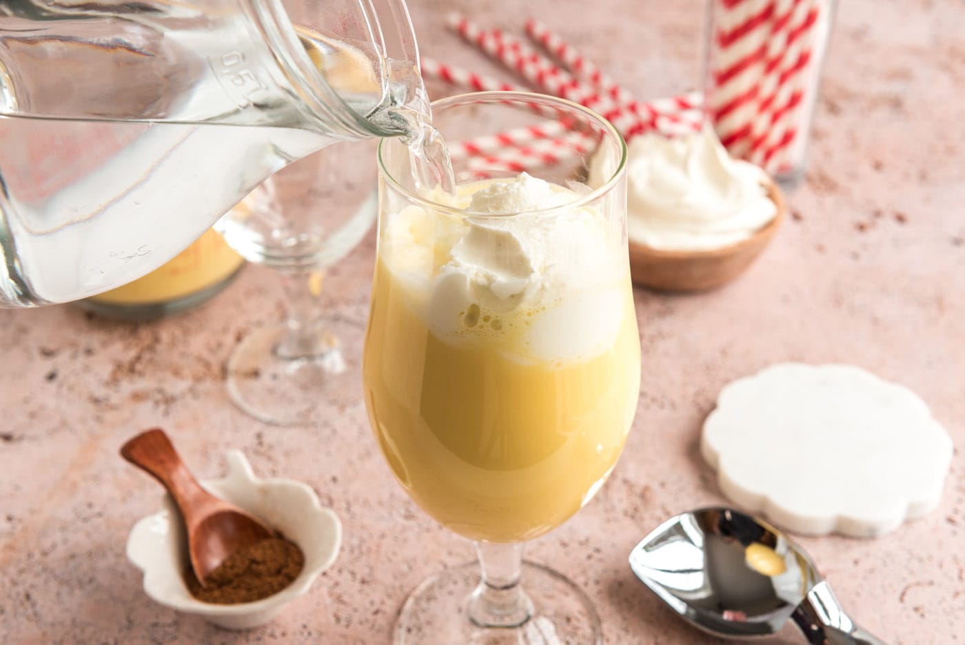 pouring club soda into glass of eggnog and ice cream