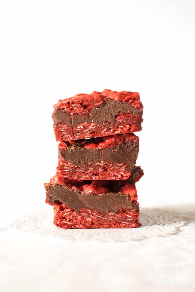 Three squares of red velvet oatmeal fudge bars stacked on top of each other. 