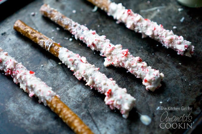 A close up photo of four white chocolate candy cane pretzel sticks.
