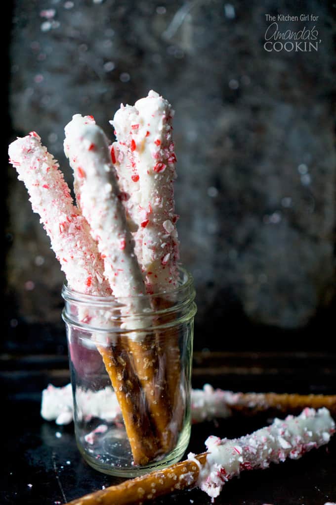 A photo of white chocolate candy cane pretzel sticks in a clear jar.