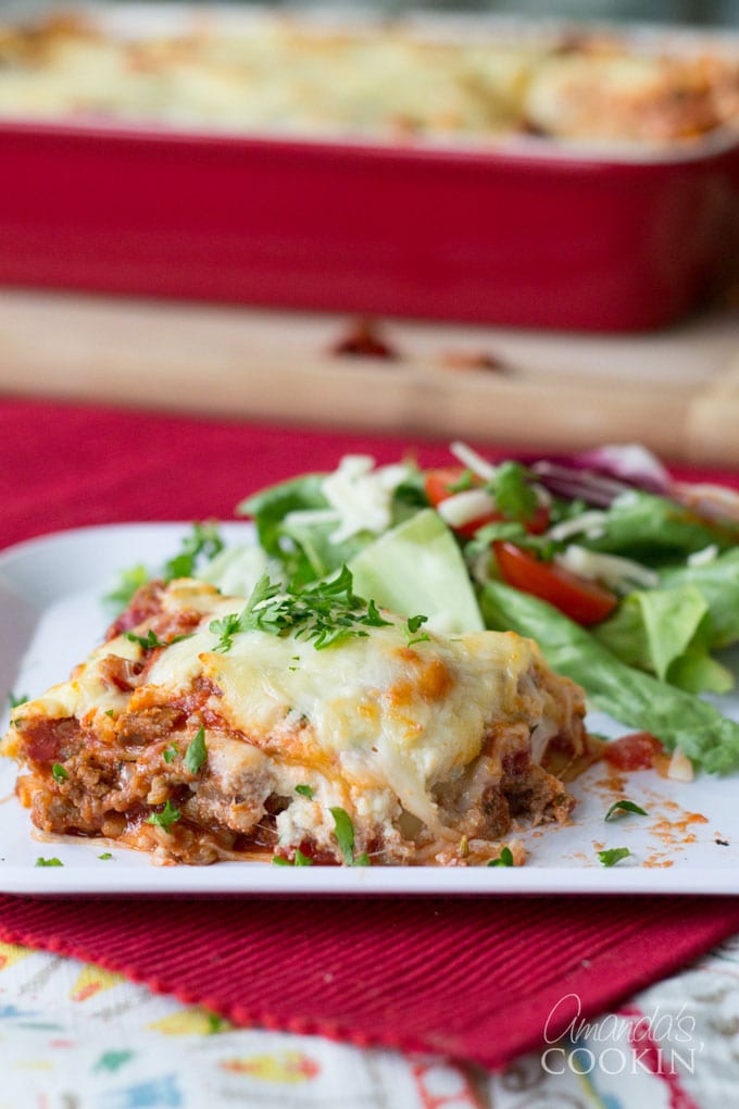 italian lasagna on a plate with salad