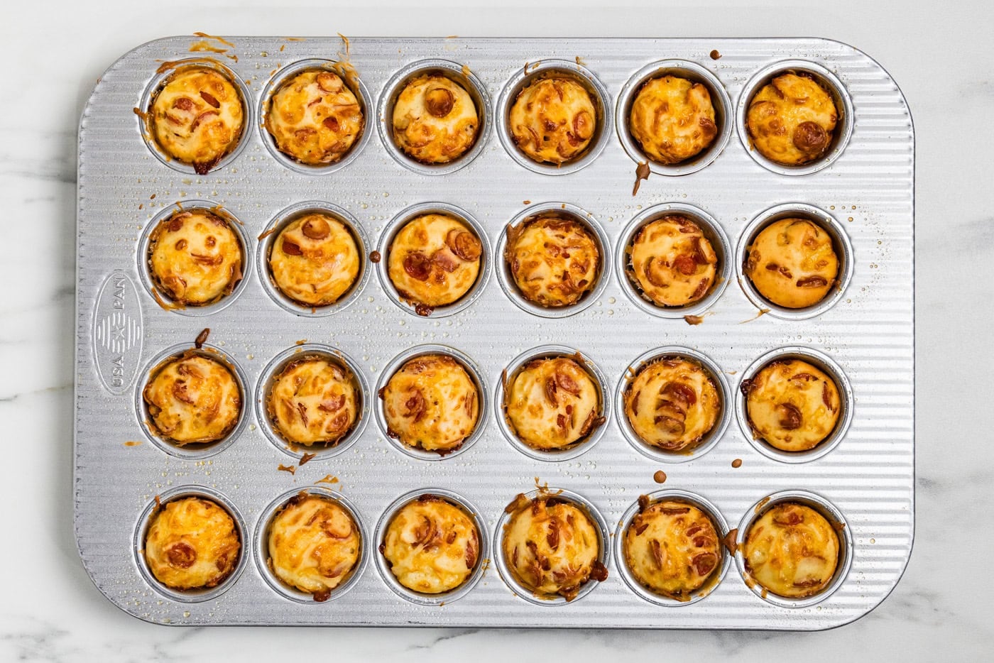 Pepperoni Pizza Puffs in mini muffin tin out of the oven