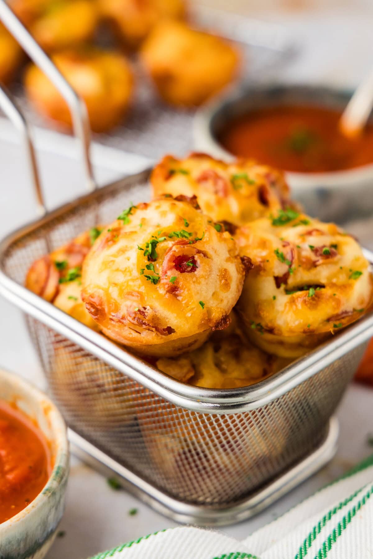 small wire basket holding Pepperoni Pizza Puffs