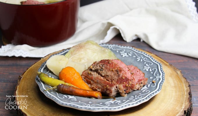 A blue plate of cooked corned beef, cabbage and carrots.