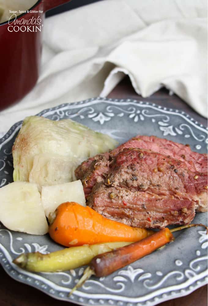 A blue plate with cooked corned beef, cabbage and carrots.