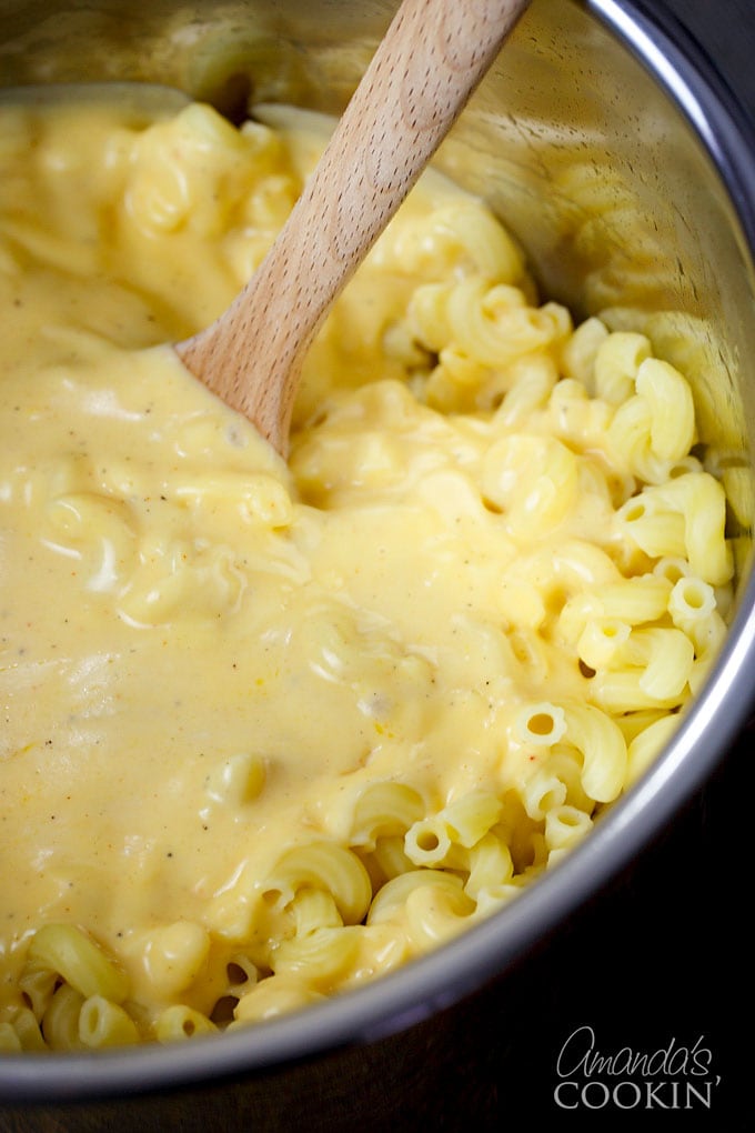 stirring cheese sauce into macaroni
