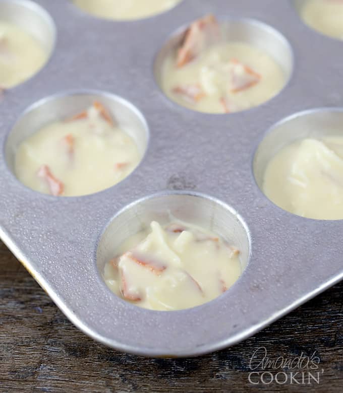 A muffin tray with pizza puff batter.