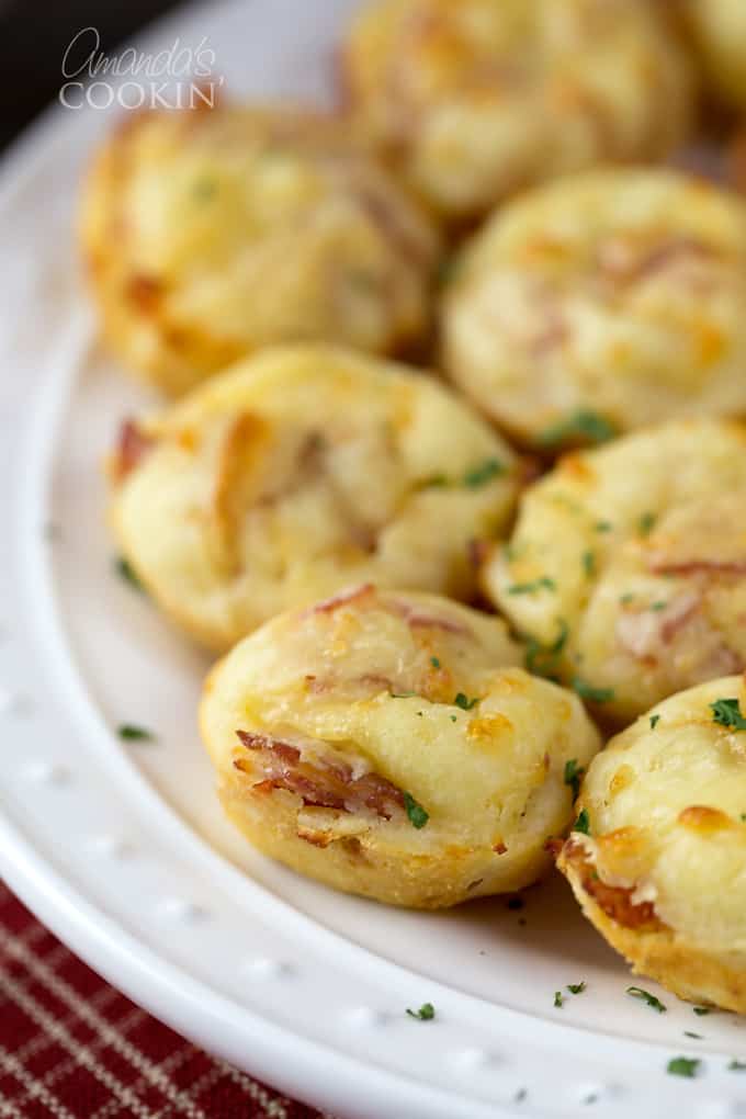 A close up of pizza puffs resting on a white plate.