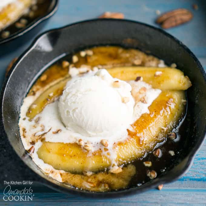 A close up of single serve banana foster topped with vanilla ice cream in a 5\" skillet.