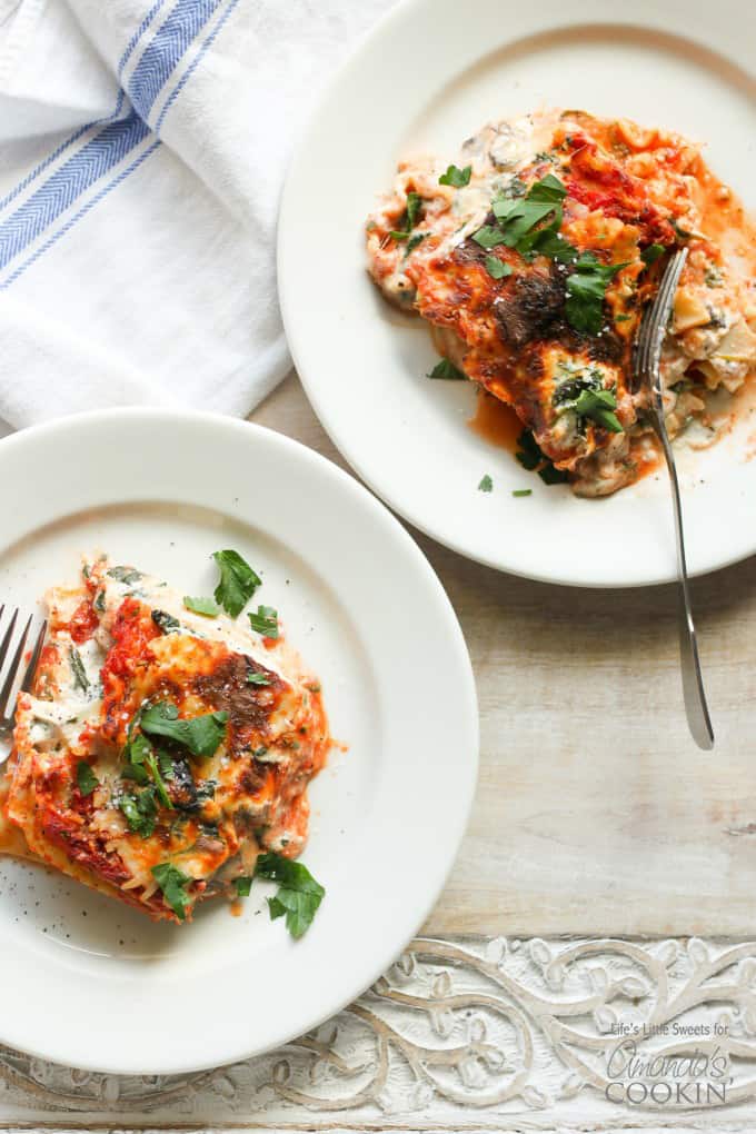 An overhead picture of two white plates with a serving of veggie lasagna on top.