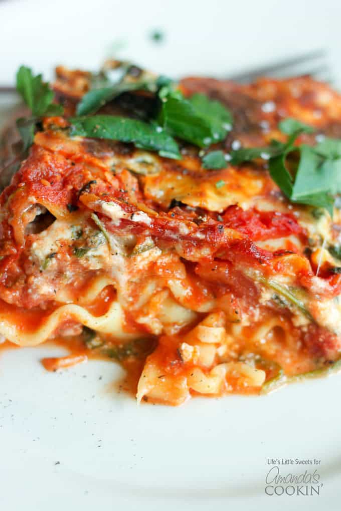 A close up of veggie lasagna on a white plate.