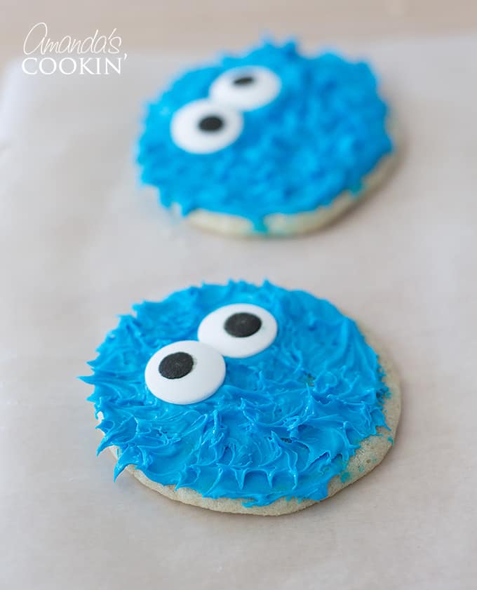 cookie monster decorated cookie on white table with another cookie in the background