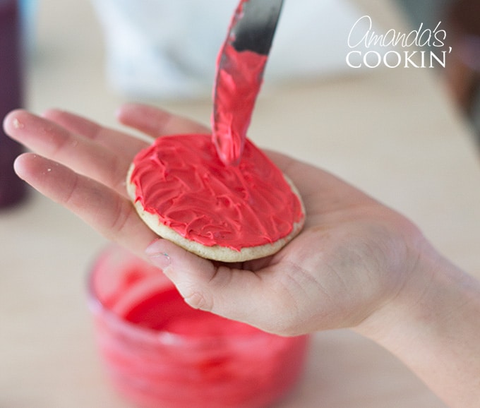 spreading frosting on a cookie