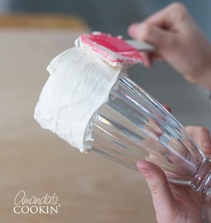 Layering on vanilla frosting to a milkshake glass