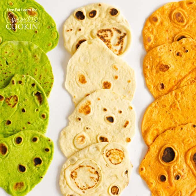 An overhead picture of three different kinds of homemade tortillas laying on a white platter.